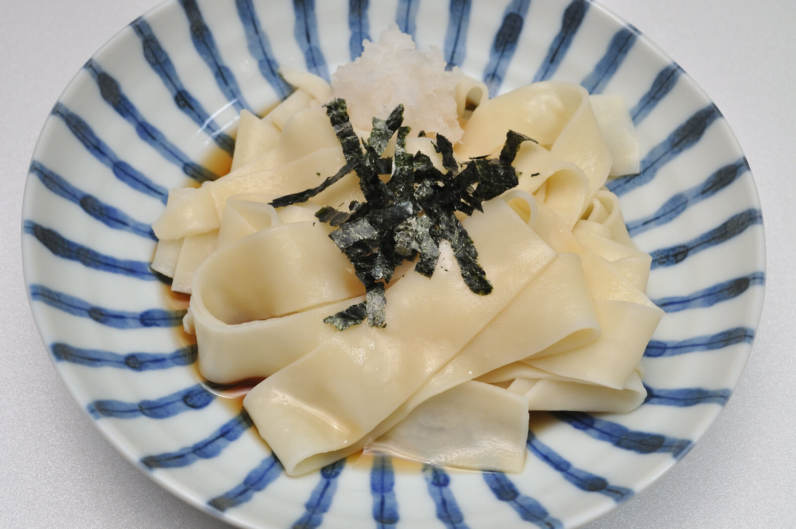 器に盛った幅広のひもかわうどんと、大根おろし・刻みのり
