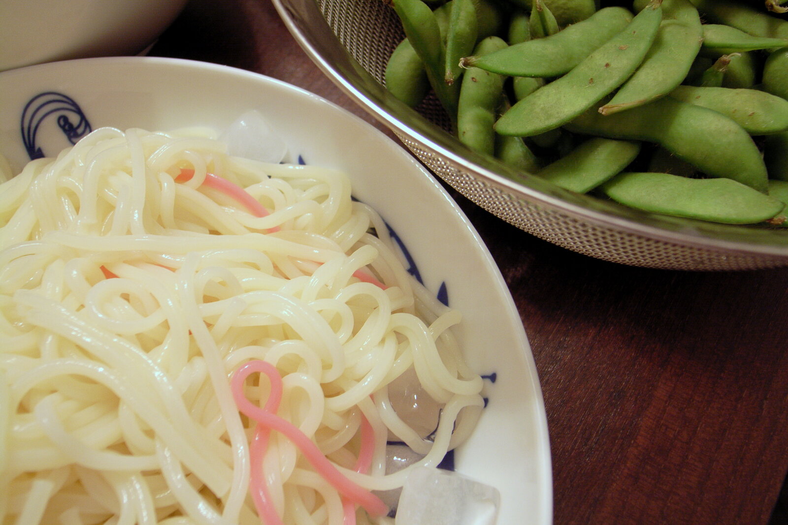 ゆでたひやむぎ。白い麺の中に、ピンクの色付きの麺がまじっている
