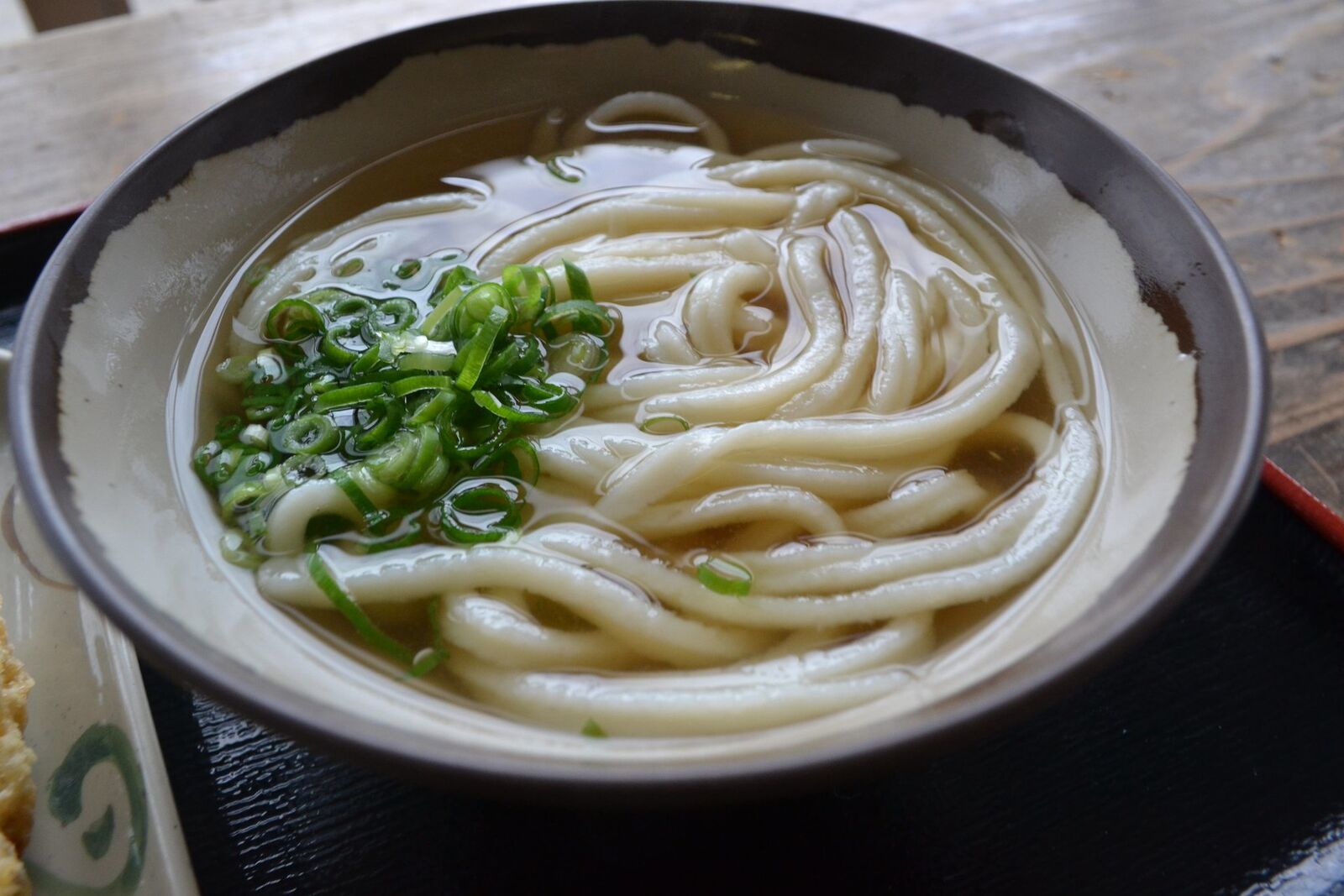 澄んだだしに刻みネギをのせた、讃岐のかけうどん