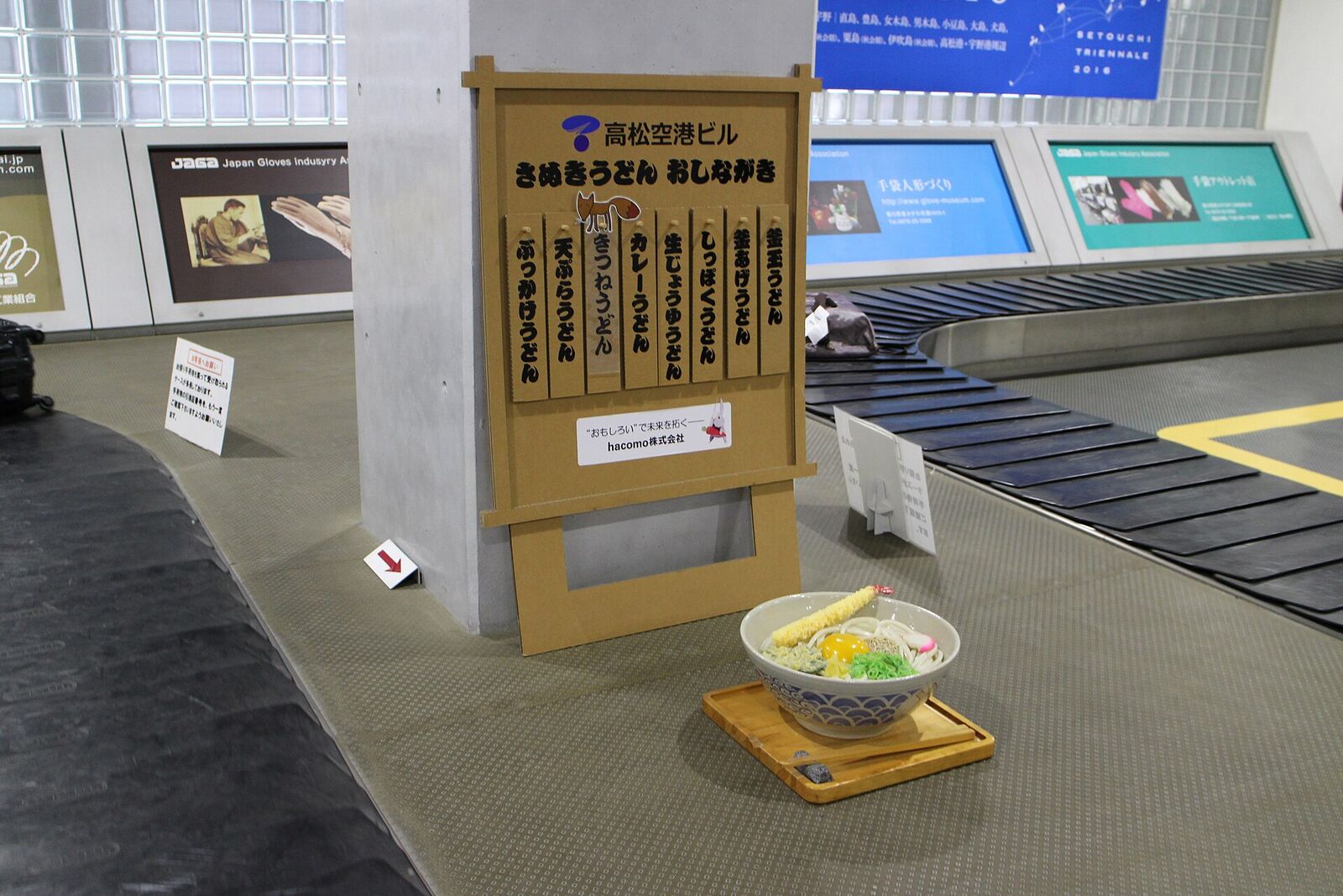 高松空港の手荷物受取所に置かれた、讃岐うどんの模型と品書き